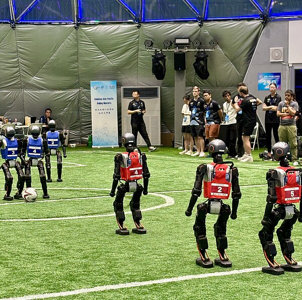 Roboterfußball Team HTWK in China Menschenähnliche Roboter beim Fußballspiel.