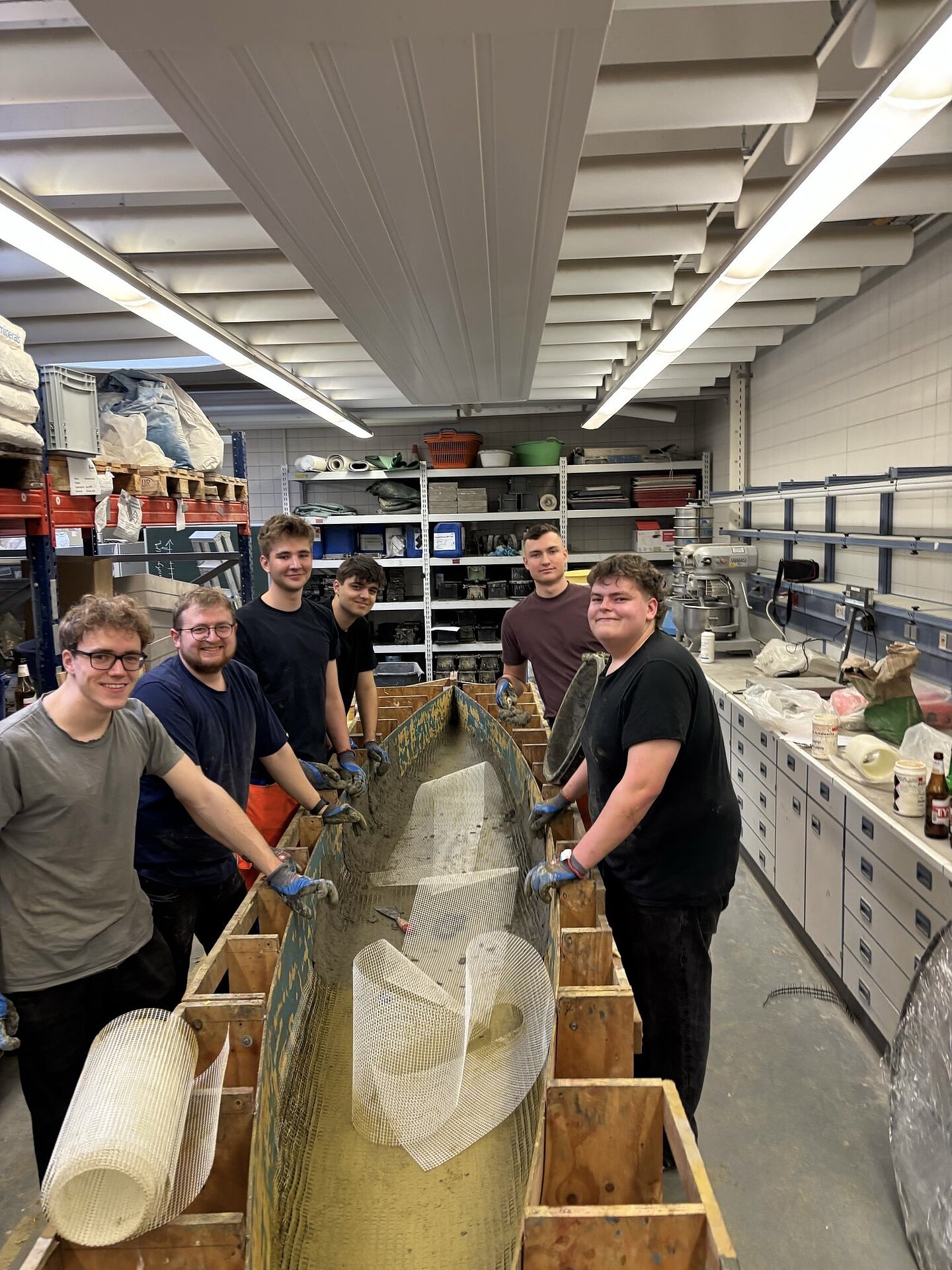 Betonieren des Kanus 2025 Gruppe von Personen baut ein Boot aus Beton
