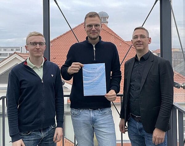 Outstanding Paper Award drei Männer stehen und halten ein Zertifikat in der Hand